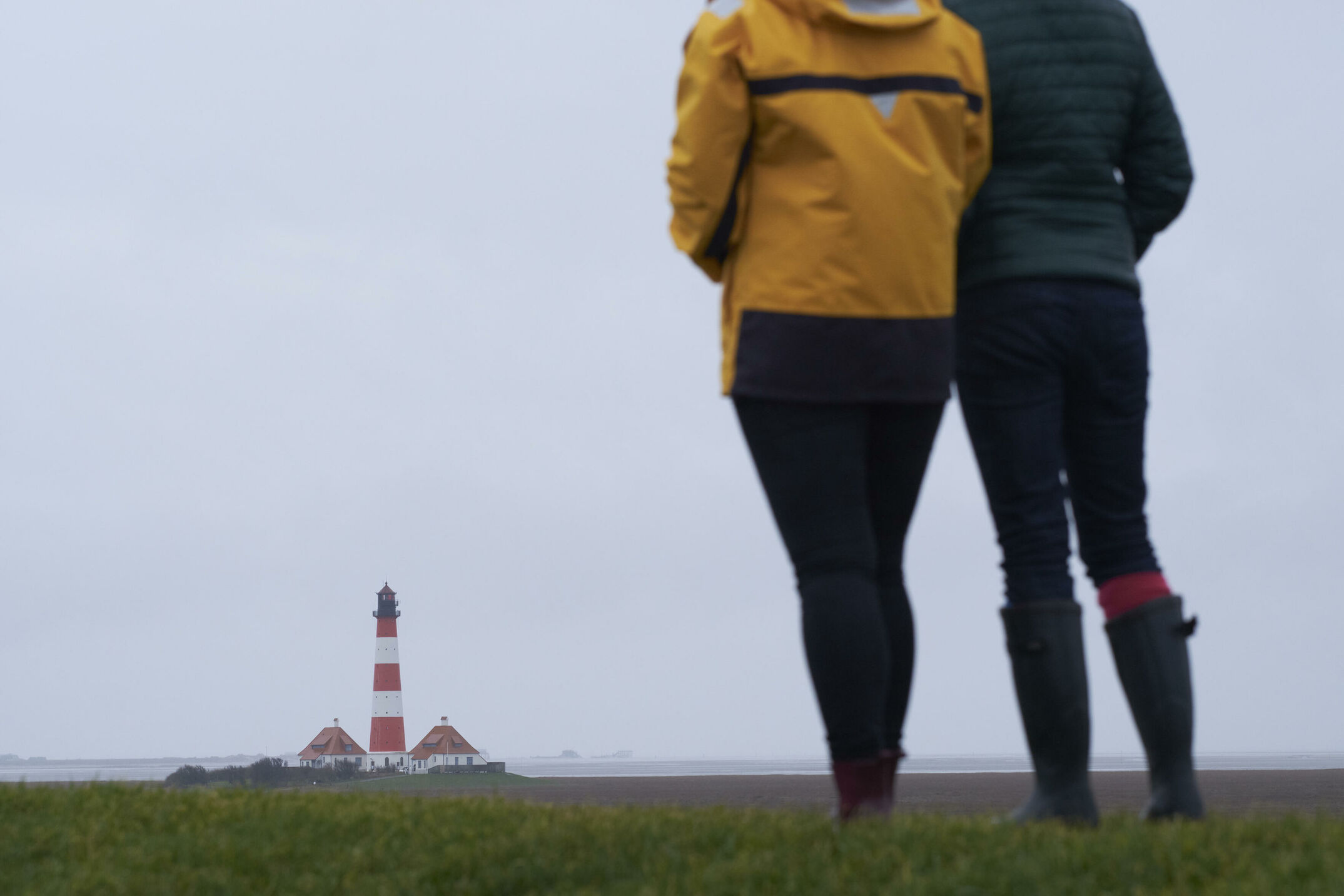 Urlaub im Winter an der Nordsee. Zwischenstopp am Leuchtturm in Westerheversand. Der Leuchtturm erhebt sich über dem Marschland.